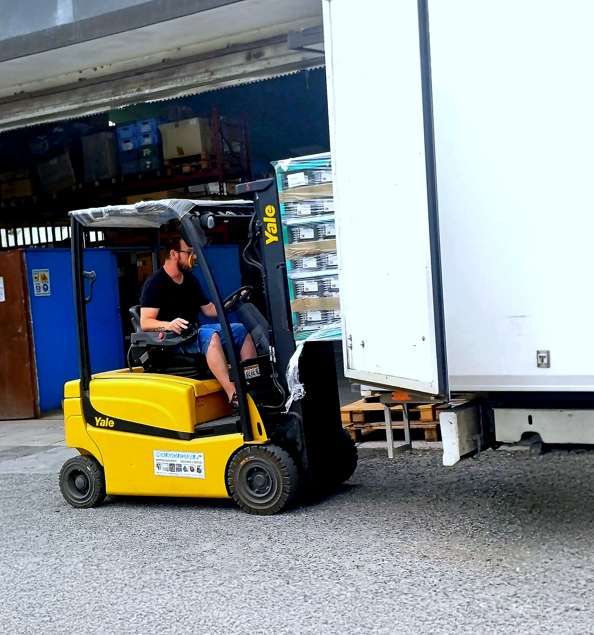 Un dipendente carica, usando un muletto, dei componenti assemblati su un furgone